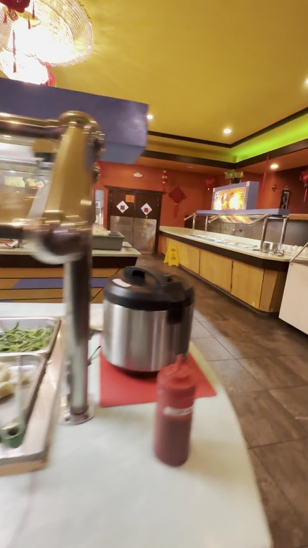 Hibachi station beside rows of hot buffet pans.