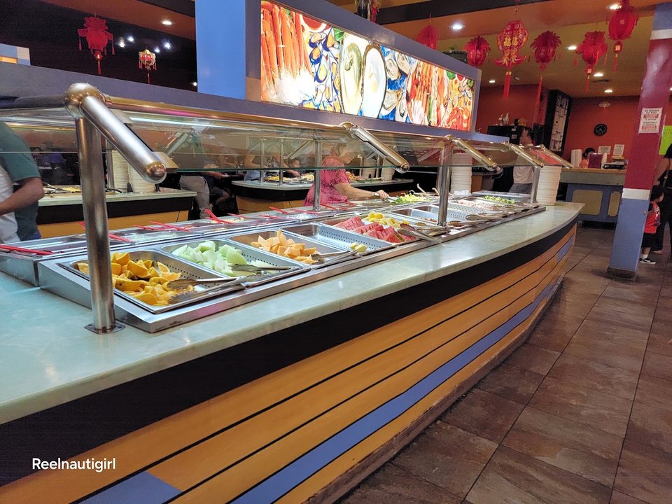 Buffet trays with sushi and Chinese dishes.
